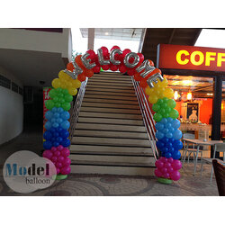 ตกแต่งทางขึ้น ด้วยซุ้มโค้งลูกโป่ง สีรุ้งและตัวอักษรลูกโป่งฟอยล์สีเงิน